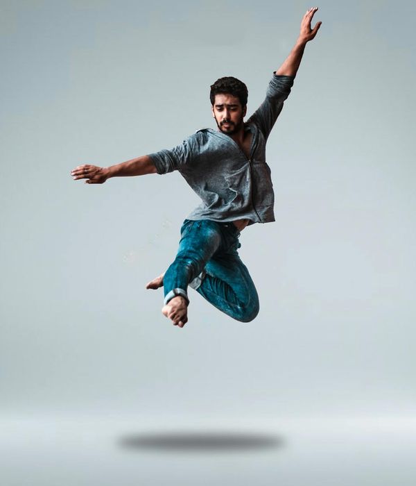 Man performing a dynamic strength movement in a bright studio.